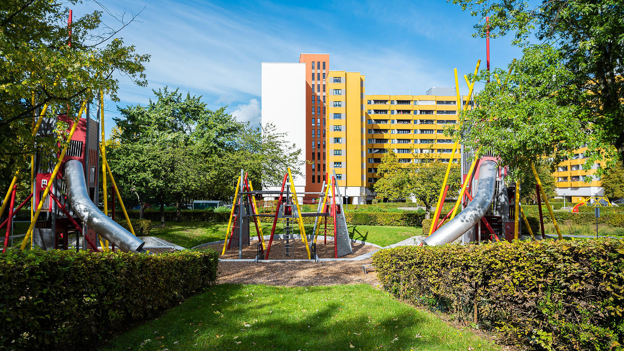 Bild zeigt Grün und neuen Spielplatz zwischen Wohnhausgruppen 911 und 922 im Märkischen Viertel.