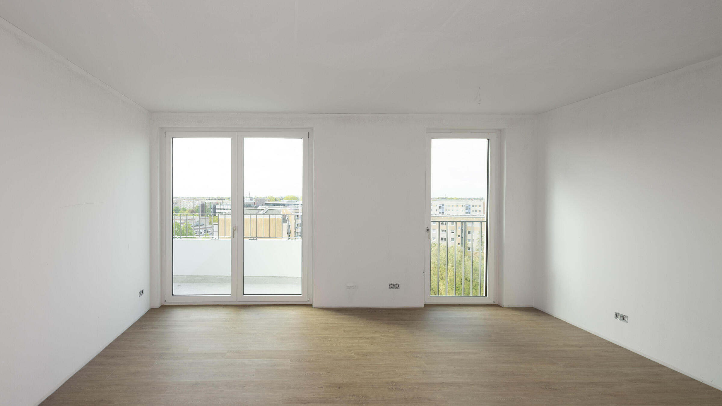 Bild zeigt Blick Zimmer in Richtung Balkonfenster in Musterwohnung in der Martin-Riesenburger-Straße.