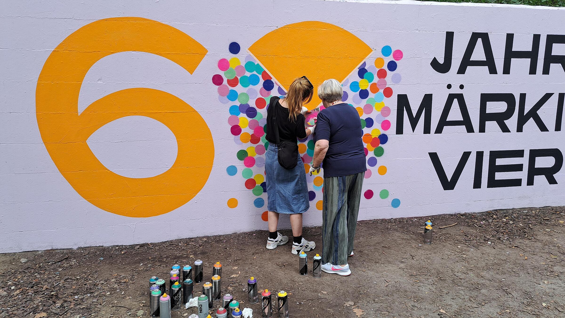 Künstlerin Chi Maulbetsch mit einer Seniorin beim Sprayen.