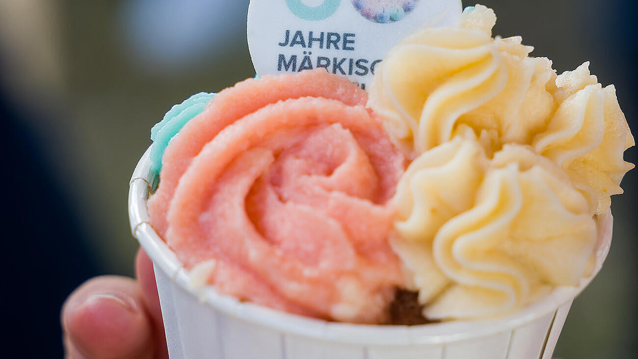 Nahaufnahme eines bunten Cupcakes mit Logo 60 Jahre Märkisches Viertel.