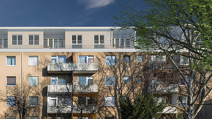 Visualisierung zeigt ein Mehrfamilienhaus, das im Dachgeschoss um eine weitere Etage aufgestockt wurde.