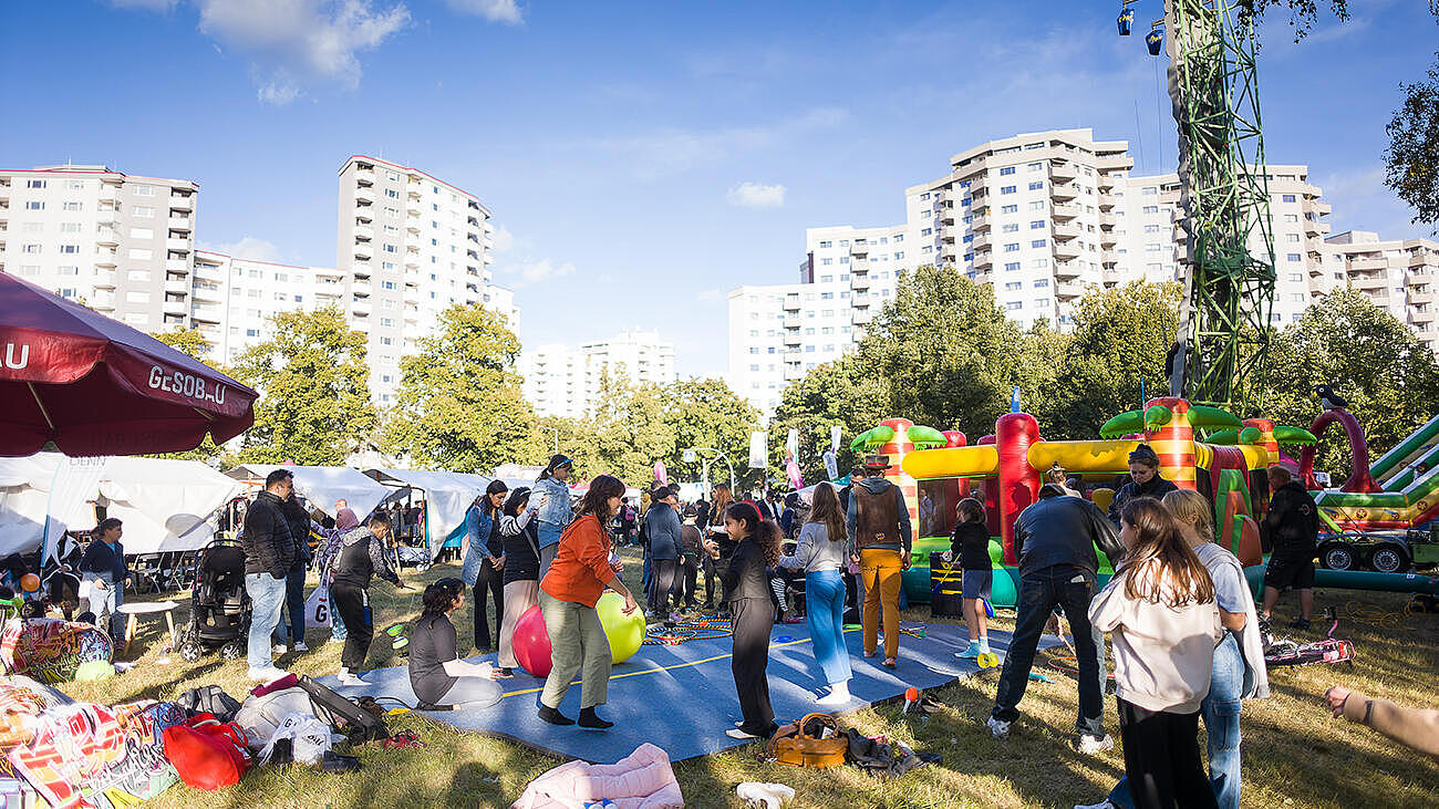 Außenaufnahme zeigt die Festwiese am Seggeluchbecken mit Ständen und im Vordergrund einem Bewegungsbereich für Kinder.