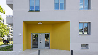 Nahaufnahme eines farblich gestalteten Eingangs des Neubaus in der Hansastraße.