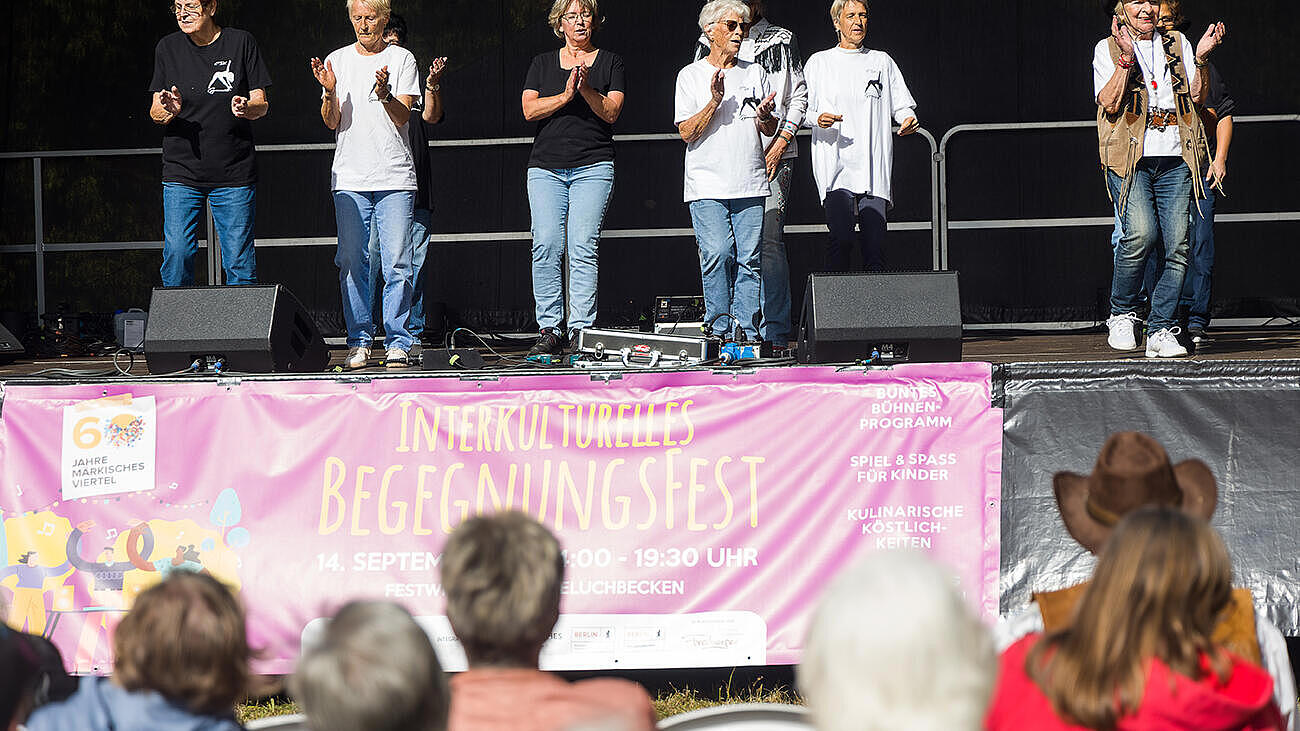 Eine Gruppe von Senior*innen tanzt Line Dance auf der Bühne des Begegnungsfestes.