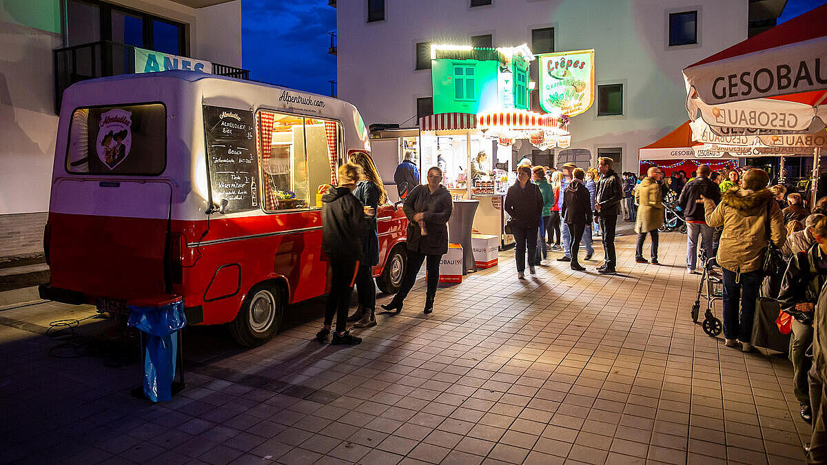 Menschen bei der Veranstaltung zu Berlin leuchtet stehen vor einen Foodtruck