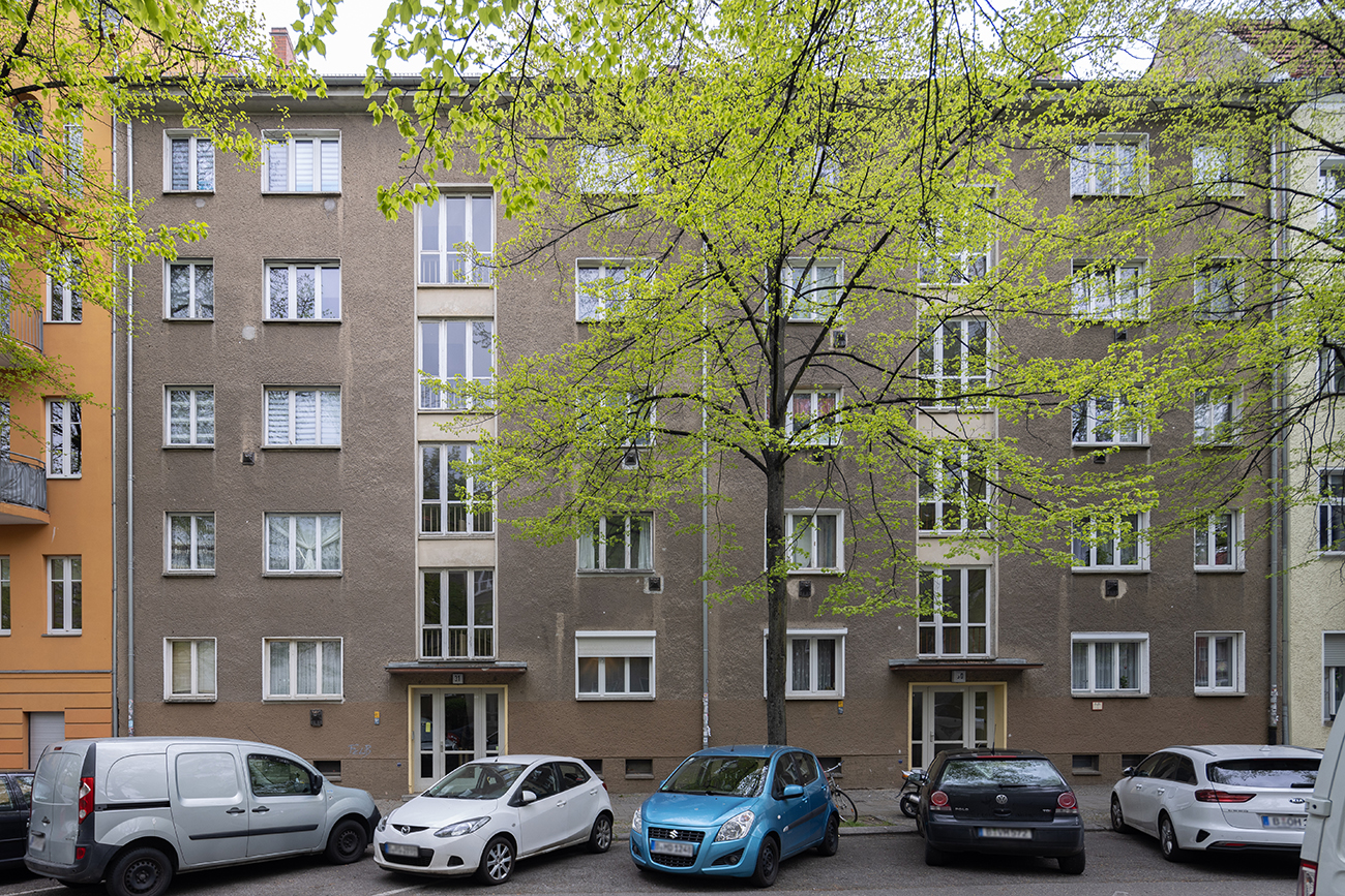 straßenseitige Fassade eines fünfstöckigen Wohnhauses vor Modernisierung.