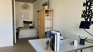 Möblierte Musterwohnung: Schreibtisch im Vordergrund mit Schlafnische