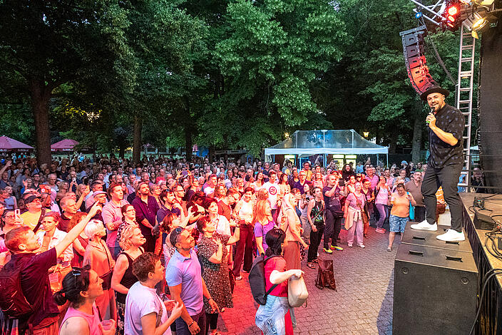 Bild zeigt Bühne mit Max Mutzke im Schlosspark Schönhausen und Publikum davor.
