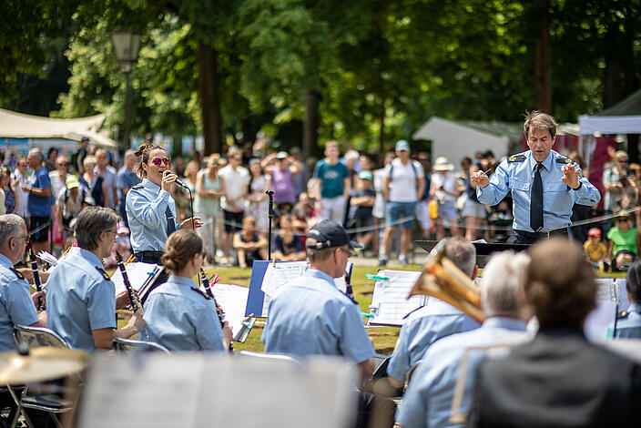 Bild zeigt Bundespolizeiorchester Berlin im Schlosspark Schönhausen, im Hintergrund Publikum und Feststände.