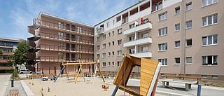 Die Wohnanlage Hamburger Platz mit Neu- und Bestandsbau inklusive Aufstockung, vom neuen SPielplatz aus gesehen.