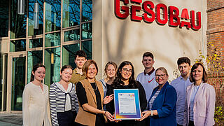 Auszubildende sowie die Ausbilungsleitung der GESOBAU nehmen die IHK-Auszeichnung für exzellente Ausbildungsqualtität entgegen. Vierte von links: Katja Krause, Bereichsleiterin Ausbildungsprüfungen bei der IHK Berlin.